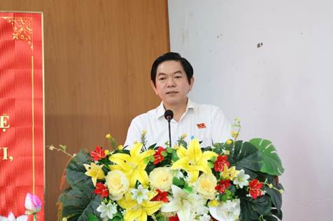 A person standing behind a podium with flowersAI-generated content may be incorrect.